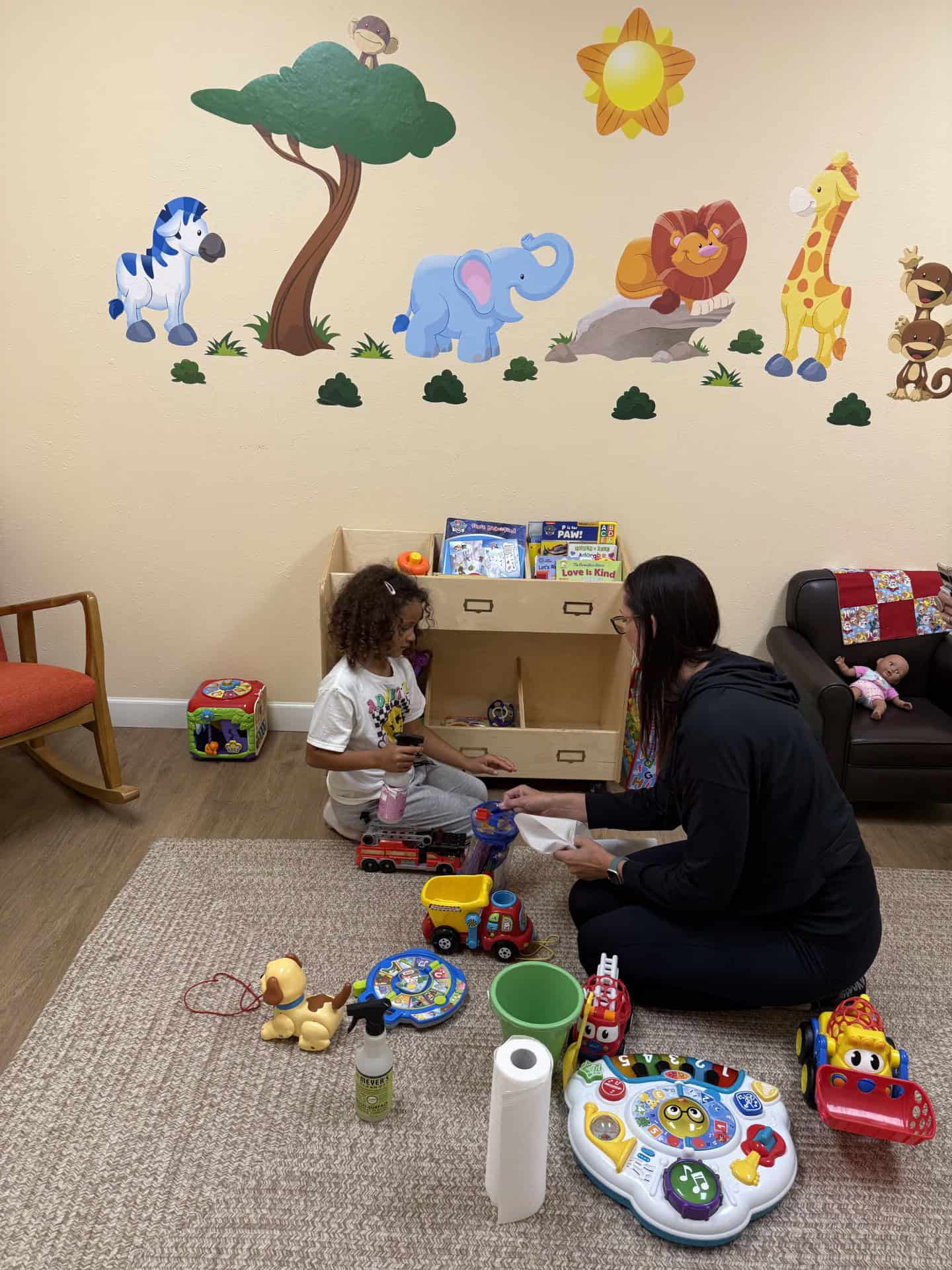 adult helping a child in a play room